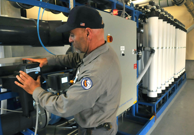 Gary Wettstein checks a control panel on a new filtration unit